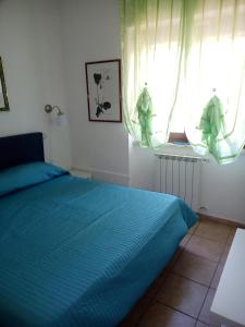 a bedroom with a blue bed and a window at Fiuggi Appartamento Turistico in Fiuggi