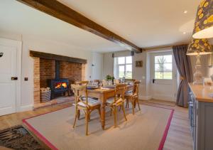 a dining room with a table and a fireplace at Manor Farm in Brampton