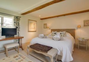 um quarto com uma cama grande e uma televisão em Manor Farm em Brampton