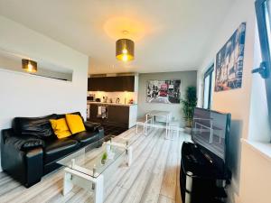 a living room with a couch and a table at Lush Cardiff Bay Apartment with Secure Parking and Fast Wifi in Cardiff