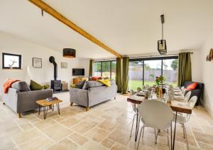 a living room with a table and chairs at Muntjac Barn in Briston