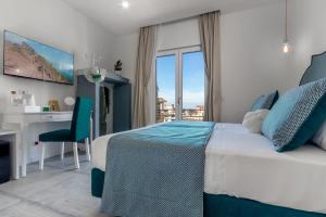 a bedroom with a bed and a desk and a window at Maison Etoile in Piano di Sorrento