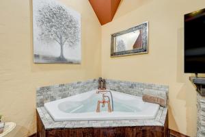 a bath tub in a room with a tv at Blissful Broken Bow Studio Fire Pit and Jacuzzi Tub in Broken Bow +17 photos