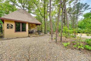 a cottage in the woods with a gravel driveway at Blissful Broken Bow Vacation Rental with Fire Pit! in Broken Bow