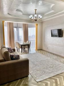 uma sala de estar com um sofá e uma mesa em iAparts Samal Tower em Almaty