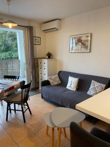 a living room with a couch and a table at Joli appartement tout confort in Hyères