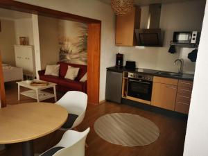 uma pequena cozinha com uma mesa e uma sala de estar em Ferienwohnung Landblick 