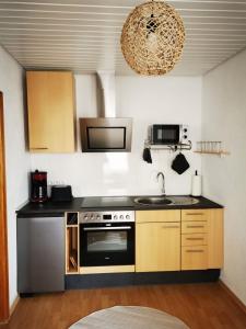 uma cozinha com um lavatório e um fogão em Ferienwohnung Landblick 