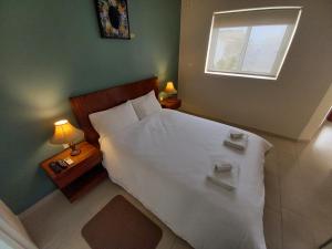 a bedroom with a large white bed with a window at Ayla Studio House I Seaside Cosy and Modern in Birżebbuġa