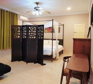 a bedroom with a bed and a chair and a table at My Excel Garden Deluxe Villa with Orchard and Pool in Air Hangat