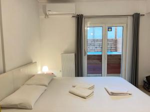 um quarto com uma cama com duas toalhas em Jacuzzi studio close to athens airport!! em Pallíni
