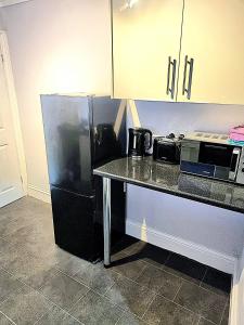 a kitchen with a black refrigerator and a counter at Bishop Retreat in Bishop Auckland