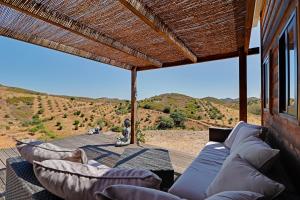 a porch with couches and a view of a mountain at Portugals Infinity - Fantástica casa de campo com vista de mar in Tavira