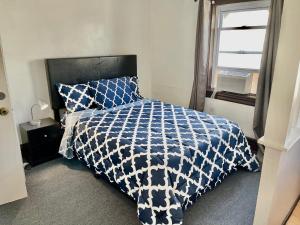 a bed with a blue and white comforter and a window at 3 Bedrooms, Boardwalk Duplex Beachblock Home! in Atlantic City