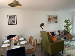 a living room with a table and a couch at Stylish 3 bedroom House In Grt Gregorie Basildon & Essex - Free Wifi, Parking, Dedicated Office & Private Garden in Basildon