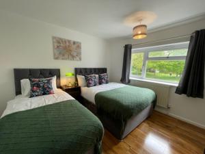 1 dormitorio con 2 camas y ventana en Stylish 3 bedroom House In Grt Gregorie Basildon & Essex - Free Wifi, Parking, Dedicated Office & Private Garden en Basildon