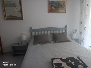 1 dormitorio con 1 cama grande y espejo en Studio Almudena, en Torrevieja