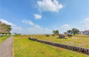 a grassy field with a stone wall next to a path at Nice Apartment In Paimboeuf With Wifi in Saint-Paimboeuf