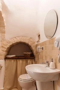 La salle de bains est pourvue d'un lavabo, de toilettes et d'un miroir. dans l'établissement Il Trullo Nascosto, à Alberobello