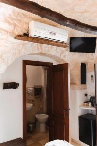 La salle de bains est pourvue de toilettes et d'un climatiseur mural. dans l'établissement Il Trullo Nascosto, à Alberobello