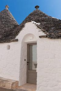 un bâtiment blanc avec une porte avec un toit dans l'établissement Il Trullo Nascosto, à Alberobello