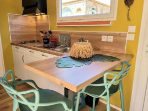 a kitchen with a wooden table and two chairs at Copacabana TINY HOUSE studio terrasse jardin in Saint-Aignan-Grand-Lieu