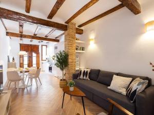 een woonkamer met een bank en een eetkamer bij Beautiful restored house with terrace in Valencia