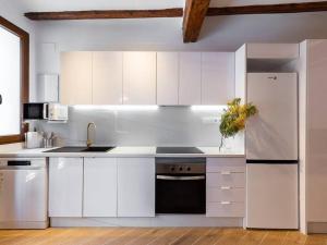 a kitchen with white cabinets and a white refrigerator at Beautiful restored house with terrace in Valencia
