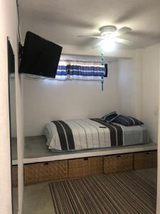 1 dormitorio con 1 cama y TV de pantalla plana en Casa Arrecife, Beach is steps away! Fast internet, Private cozy room! en La Ventana
