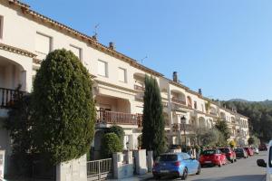 una fila de edificios con coches aparcados delante de ellos en Vacaciones en maresme casa para 7 personas, en Barcelona