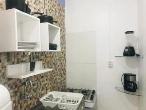 a small kitchen with a sink and a stove at La casita lilás in Beberibe