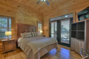 1 dormitorio con cama, paredes de madera y suelo de madera en Mountain Solace w Mtn Views Paved Roads Hot Tub, en Blue Ridge