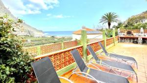 a group of chairs sitting on a patio overlooking the ocean at Casa Rural Ondina in Hermigua