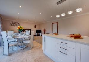 een keuken en eetkamer met een tafel en stoelen bij Nursery Cottage in Clippesby