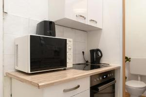 un forno a microonde seduto sopra un bancone in cucina di Vibrant 1BR - Ideal Long Stay Accommodation a Vienna