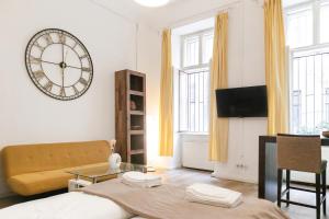 un soggiorno con un grande orologio sul muro di Vibrant 1BR - Ideal Long Stay Accommodation a Vienna