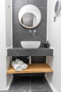 a bathroom with a sink and a mirror at Vino luxury suites in Agia Anna Naxos +35 photos