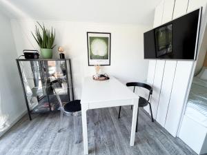 um quarto com uma mesa branca e uma televisão em FeWo Frieda's Platz am Meer em Dangast