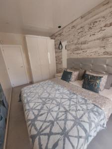 1 dormitorio con 1 cama grande y pared de ladrillo en ORLANDO LUXURY APARTAMENT en Adeje
