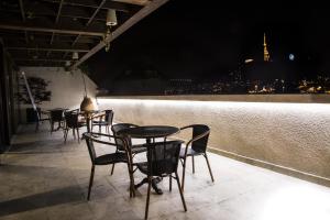 a row of tables and chairs on a rooftop at night at Hotel ZP Palace in Tbilisi City