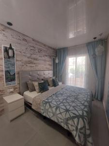 una camera con letto e muro di mattoni di ORLANDO LUXURY APARTAMENT ad Adeje