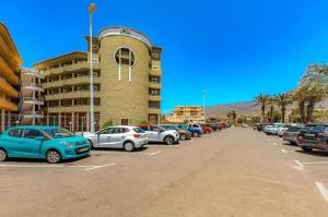 a parking lot with cars parked in front of a building at ORLANDO LUXURY APARTAMENT in Adeje