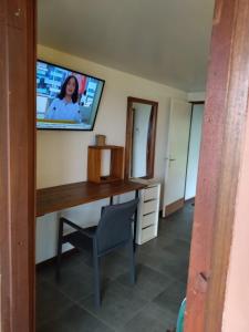 Zimmer mit einem Schreibtisch und einem TV an der Wand in der Unterkunft LE CHALET DOMAINE DU ROCHER in Bourda