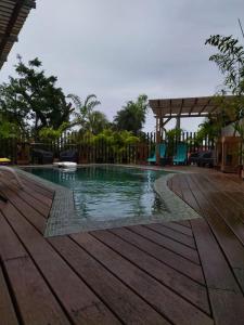 einen Pool in einem Resort mit einer Holzterrasse in der Unterkunft LE CHALET DOMAINE DU ROCHER in Bourda