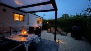 un patio con una mesa con velas. en PURE - Chalet Zeeland - garden out of sight, en Hoek