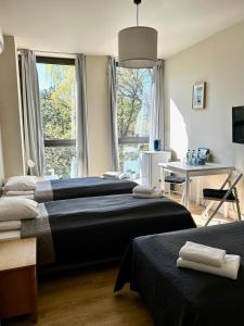 a bedroom with two beds and a desk and a window at Peperino in Gdańsk