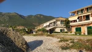 a large building with mountains in the background at Maresol Lefkada in Nikiana