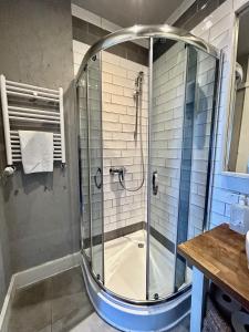 a shower with a glass door in a bathroom at Peperino in Gdańsk