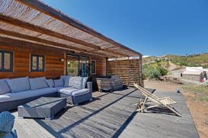un patio con sofá y sillas en una terraza de madera en Portugals Infinity - Fantástica casa de campo com vista de mar en Tavira