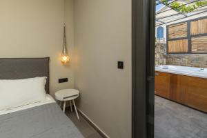 a bedroom with a bed and a sink and a tub at Villa Dimitra - Saint Nikolas Retreat in Faraklata